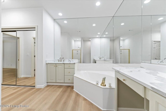 3447 Hurstbourne Ridge Blvd, Louisville, KY 40299 - bathroom featuring wood finished floors, a bath, two vanities, a stall shower, and recessed lighting