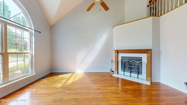 512 Valley College Dr, Louisville, KY 40272 - unfurnished living room with wood finished floors, ceiling fan, baseboards, high vaulted ceiling, and a tile fireplace