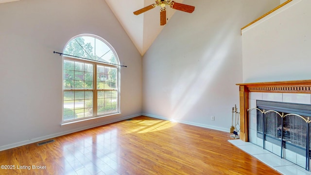 512 Valley College Dr, Louisville, KY 40272 - unfurnished living room with wood finished floors, ceiling fan, a tiled fireplace, baseboards, and high vaulted ceiling