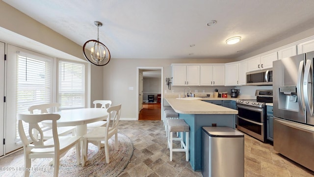 512 Valley College Dr, Louisville, KY 40272 - kitchen with appliances with stainless steel finishes, stone tile flooring, white cabinets, and a chandelier