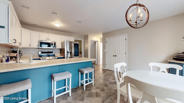 512 Valley College Dr, Louisville, KY 40272 - kitchen featuring stainless steel appliances, dark stone finish flooring, a kitchen bar, a peninsula, and white cabinets