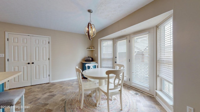512 Valley College Dr, Louisville, KY 40272 - dining space featuring stone finish floors, a chandelier, and baseboards