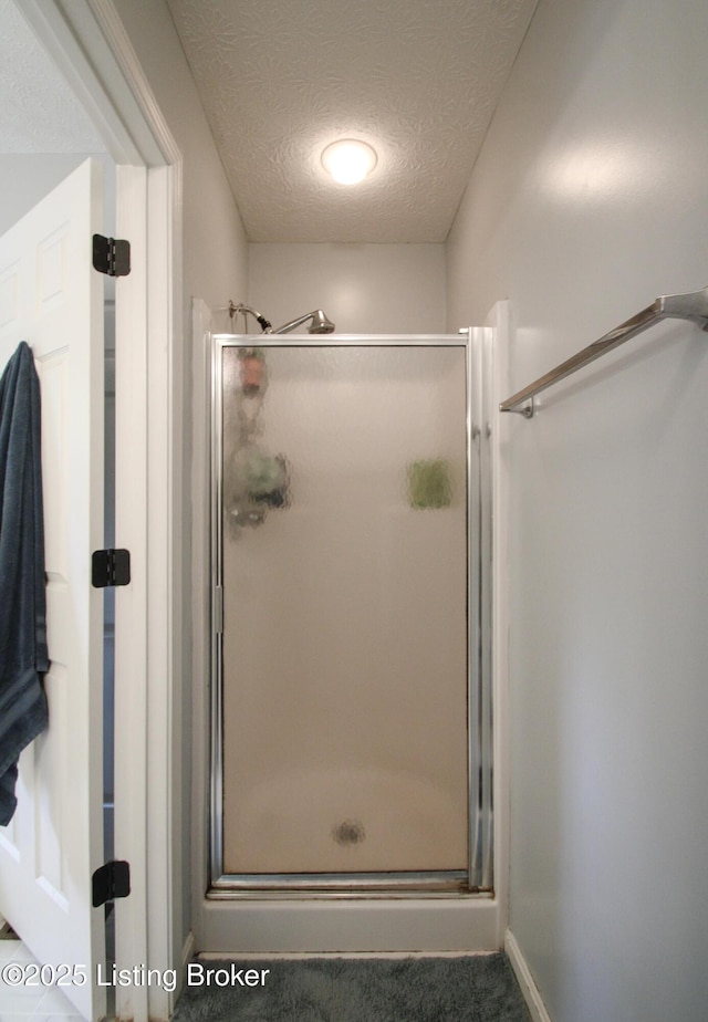 512 Valley College Dr, Louisville, KY 40272 - bathroom with a stall shower, a textured ceiling, and baseboards