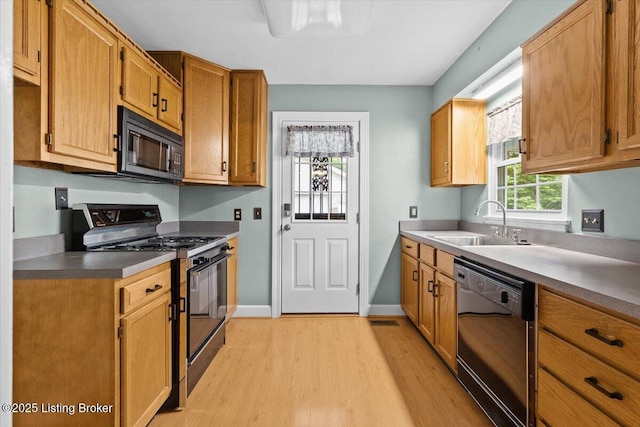 3306 Grandview Ave, Louisville, KY 40207 - kitchen with black appliances, light wood-style floors, and brown cabinetry