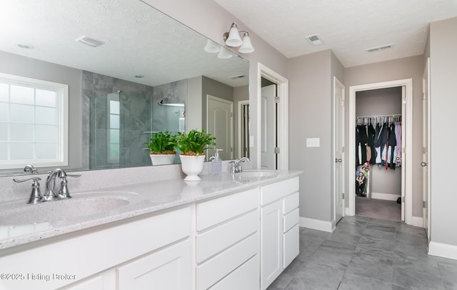 17121 Piton Way, Louisville, KY 40245 - bathroom with double vanity, a stall shower, baseboards, a walk in closet, and a textured ceiling