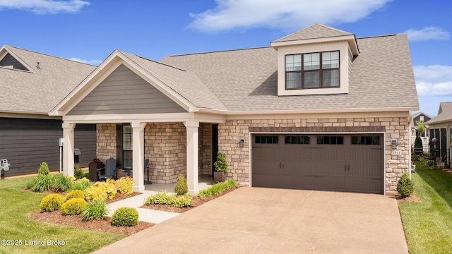 1911 Dressage Cir, Louisville, KY 40245 - view of front of house featuring concrete driveway, stone siding, a shingled roof, covered porch, and a front yard