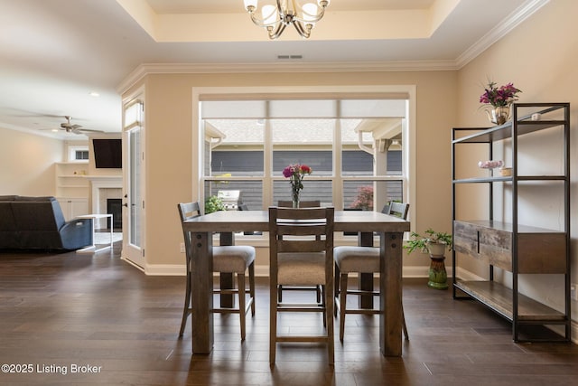 1911 Dressage Cir, Louisville, KY 40245 - dining area with a chandelier, dark wood finished floors, a raised ceiling, a fireplace, and crown molding