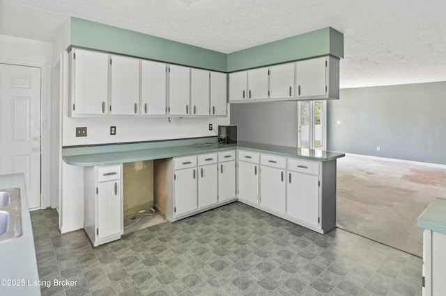 360 Pumpkin Rd, Shepherdsville, KY 40165 - kitchen featuring white cabinets, a textured ceiling, light floors, a peninsula, and baseboards