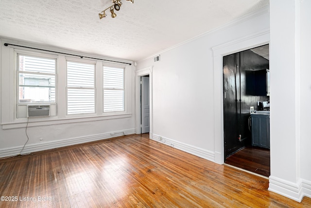 1337 S 1st St Unit 3R, Louisville, KY 40208 - empty room featuring wood-type flooring, baseboards, a textured ceiling, cooling unit, and ornamental molding