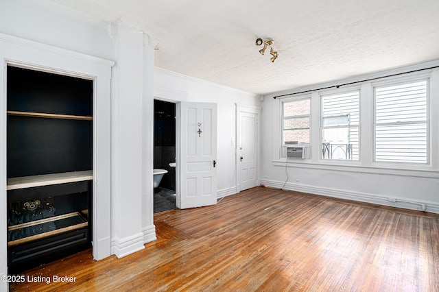 1337 S 1st St Unit 3R, Louisville, KY 40208 - unfurnished living room with light wood-style floors, cooling unit, baseboards, a textured ceiling, and ornamental molding