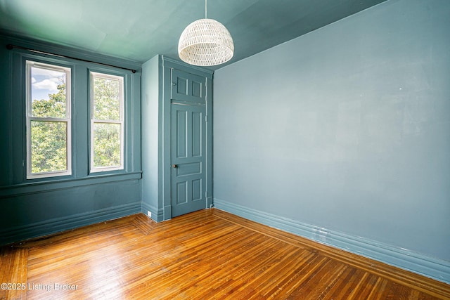 1337 S 1st St Unit 3R, Louisville, KY 40208 - empty room featuring baseboards, light wood-type flooring, and a chandelier