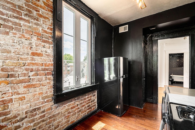 1337 S 1st St Unit 3R, Louisville, KY 40208 - kitchen featuring freestanding refrigerator, hardwood / wood-style floors, brick wall, gas stove, and light countertops
