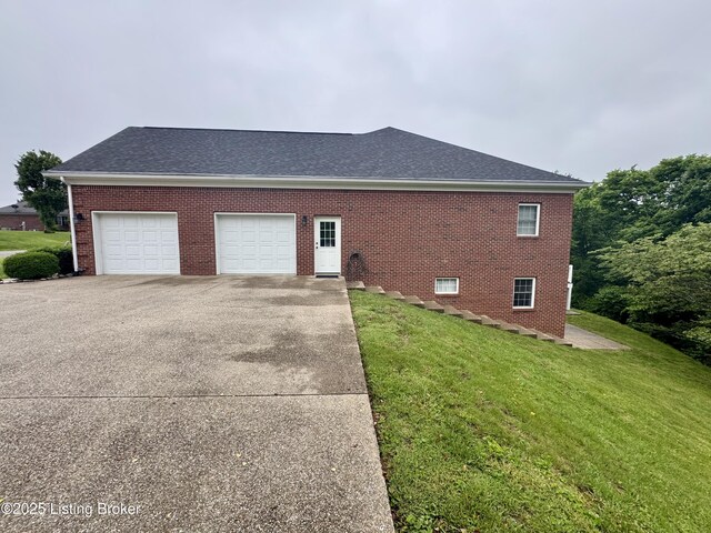 144 Woodhill Rd, Bardstown, KY 40004 - view of side of home with a garage, driveway, a lawn, brick siding, and a shingled roof