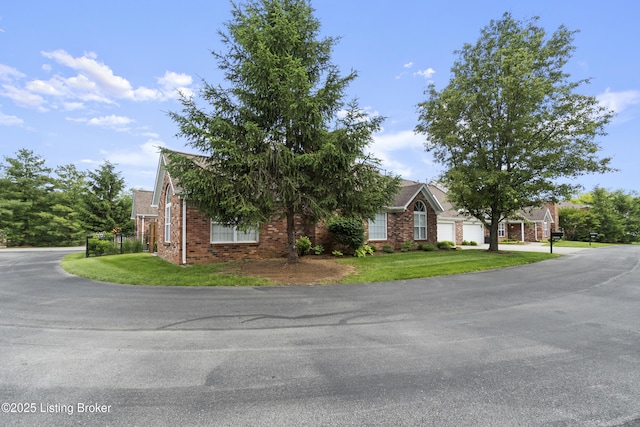 10106 Blossom Tree Way, Louisville, KY 40241 - obstructed view of property with an attached garage, a front yard, brick siding, and driveway