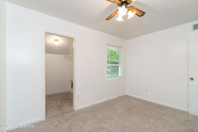 5612 Oakridge Pl, Louisville, KY 40229 - unfurnished bedroom with carpet, a walk in closet, a closet, baseboards, and a textured ceiling
