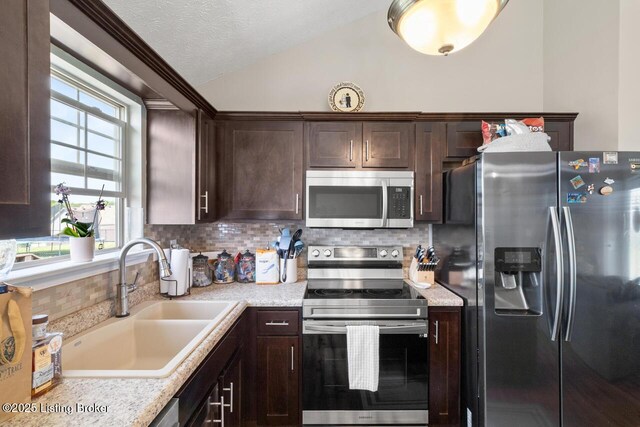 238 Crossfield Dr, Mt Washington, KY 40047 - kitchen with stainless steel appliances, a sink, dark brown cabinets, vaulted ceiling, and light countertops