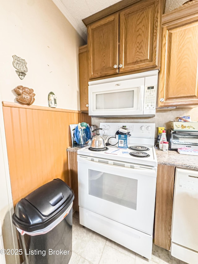 1073 Post-Tousey Rd Unit C, Caneyville, KY 42721 - kitchen featuring white appliances, crown molding, wainscoting, brown cabinets, and light tile patterned floors