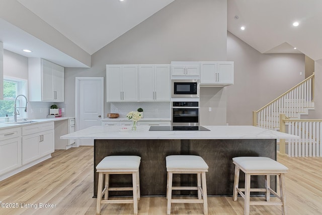 2519 Belknap Beach Rd, Prospect, KY 40059 - kitchen with a sink, oven, built in microwave, high vaulted ceiling, and white cabinetry