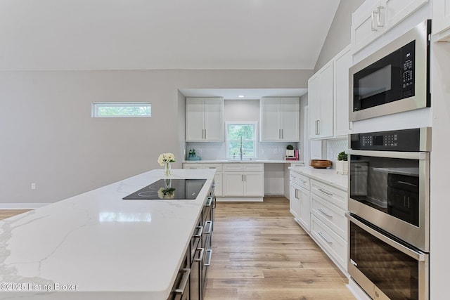 2519 Belknap Beach Rd, Prospect, KY 40059 - kitchen with black appliances, light stone counters, white cabinetry, decorative backsplash, and light wood-style flooring