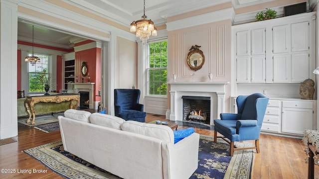 316 E Cross Main St, New Castle, KY 40050 - living area featuring a fireplace with flush hearth, a chandelier, light wood-style flooring, and ornamental molding