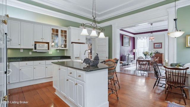316 E Cross Main St, New Castle, KY 40050 - kitchen featuring white appliances, a breakfast bar area, hardwood / wood-style floors, white cabinetry, and crown molding
