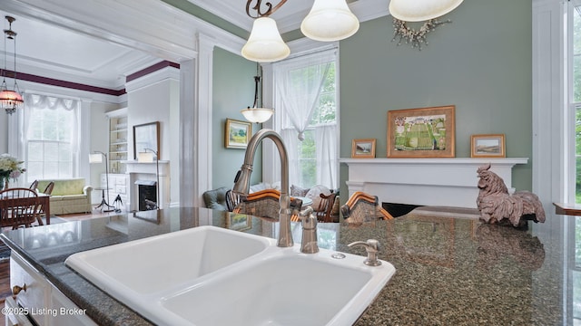 316 E Cross Main St, New Castle, KY 40050 - kitchen view of a fireplace, a sink, ornamental molding, hanging light fixtures, and dark stone counters