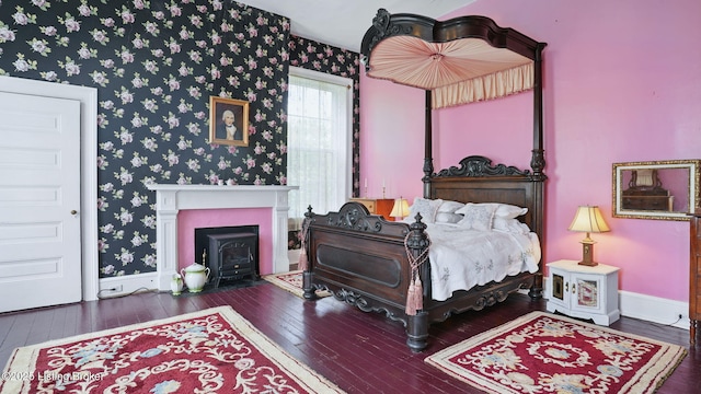 316 E Cross Main St, New Castle, KY 40050 - bedroom with hardwood / wood-style floors, wallpapered walls, a wood stove, and baseboards