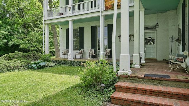 316 E Cross Main St, New Castle, KY 40050 - doorway to property featuring covered porch, a lawn, a balcony, and brick siding