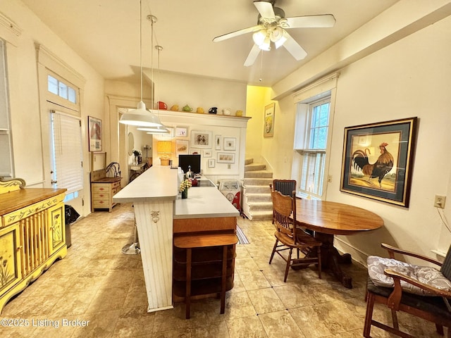 218 Locust St, Jeffersonville, IN 47130 - kitchen featuring light countertops, ceiling fan, hanging light fixtures, a kitchen bar, and a kitchen island