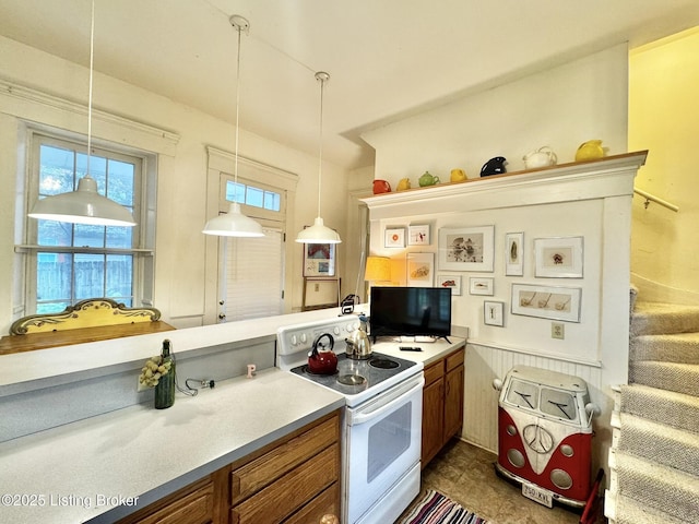 218 Locust St, Jeffersonville, IN 47130 - kitchen featuring electric stove, brown cabinets, light countertops, hanging light fixtures, and wainscoting