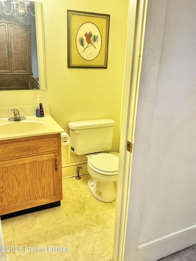 218 Locust St, Jeffersonville, IN 47130 - bathroom featuring toilet, vanity, a chandelier, and baseboards