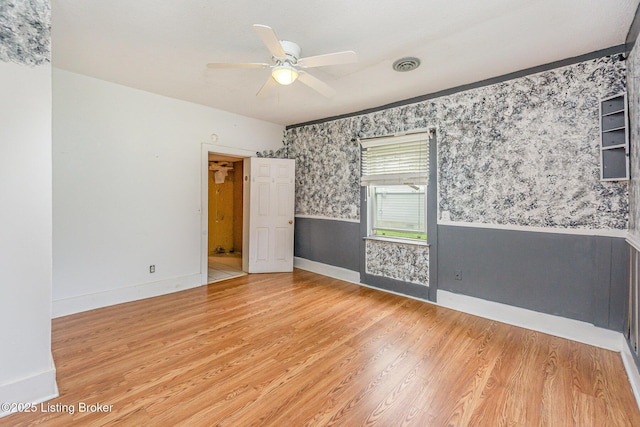 793 Samuels Loop, Coxs Creek, KY 40013 - empty room with wallpapered walls, a ceiling fan, a wainscoted wall, wood finished floors, and baseboards