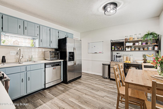 7020 Field View Ct, Louisville, KY 40291 - kitchen with stainless steel appliances, a sink, light wood-type flooring, light countertops, and backsplash
