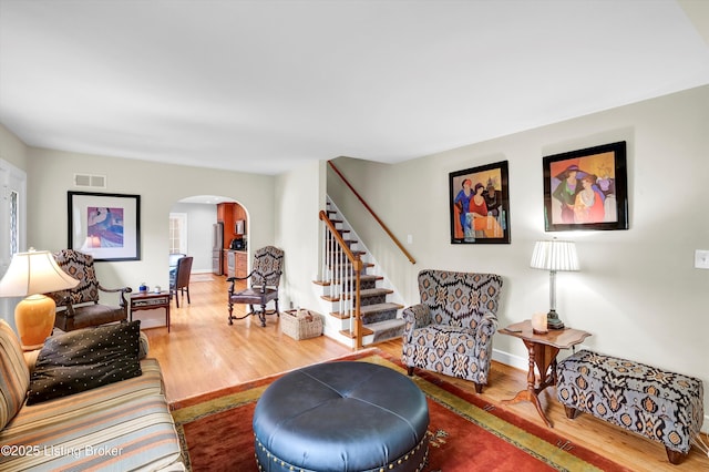 2501 Newburg Rd, Louisville, KY 40205 - living room featuring arched walkways, wood finished floors, stairs, and baseboards