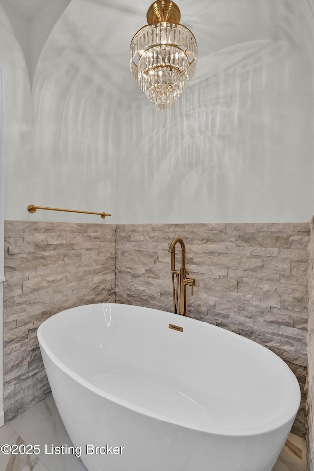 2501 Newburg Rd, Louisville, KY 40205 - full bath with tile walls, a freestanding bath, a wainscoted wall, a chandelier, and marble finish flooring