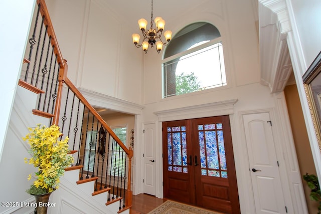 9200 Axminster Dr, Louisville, KY 40299 - entrance foyer featuring a chandelier, stairs, a towering ceiling, french doors, and a decorative wall