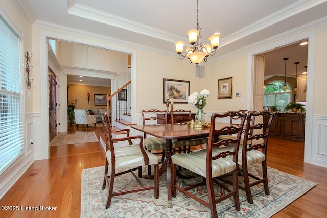 9200 Axminster Dr, Louisville, KY 40299 - dining area with ornamental molding, stairway, light wood-style floors, a decorative wall, and a chandelier