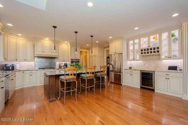 9200 Axminster Dr, Louisville, KY 40299 - kitchen featuring wine cooler, stainless steel appliances, decorative backsplash, a kitchen breakfast bar, and light wood-style flooring