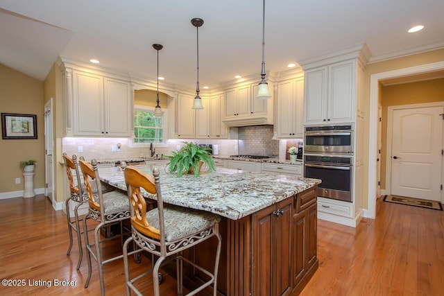 9200 Axminster Dr, Louisville, KY 40299 - kitchen with appliances with stainless steel finishes, light stone counters, baseboards, a kitchen bar, and a sink