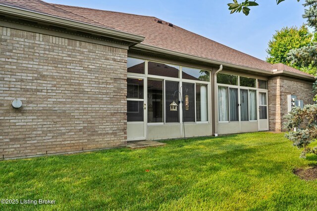 1208 Elderberry Ln, Louisville, KY 40243 - rear view of house featuring a sunroom, a yard, a shingled roof, and brick siding