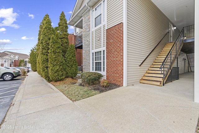 10200 Deer Vista Dr Unit 201, Louisville, KY 40291 - view of side of property featuring brick siding, stairway, and uncovered parking