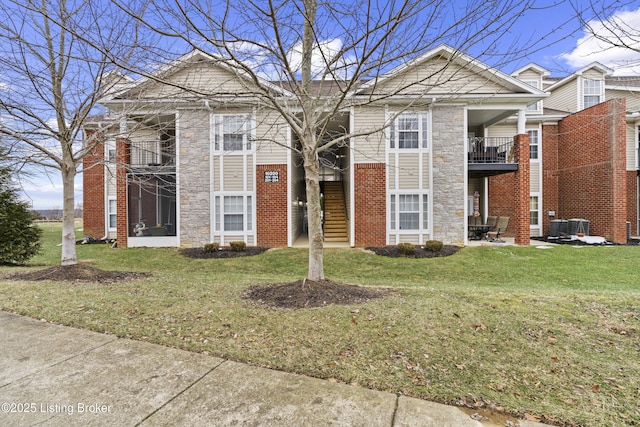 10200 Deer Vista Dr Unit 201, Louisville, KY 40291 - view of front facade featuring stone siding, a front lawn, brick siding, and cooling unit