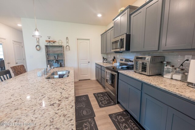 11905 Cascade Falls Trl, Louisville, KY 40229 - kitchen featuring stainless steel appliances, a sink, light wood finished floors, decorative backsplash, and recessed lighting