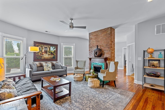 living room with a ceiling fan, wood finished floors, a fireplace, and baseboards