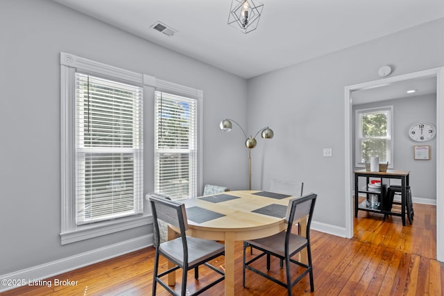 dining space with hardwood / wood-style floors, baseboards, and plenty of natural light