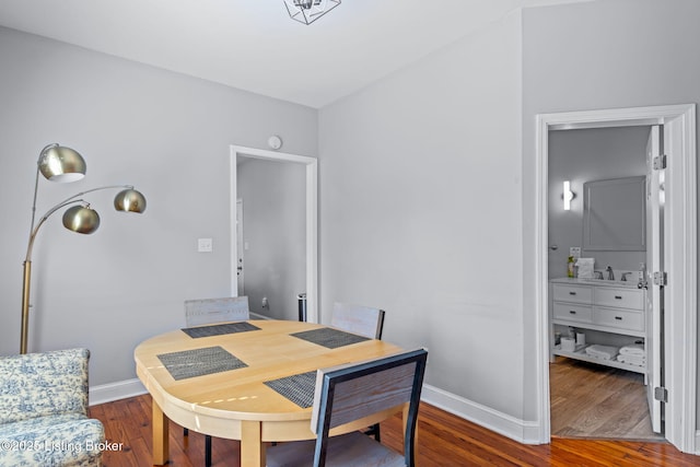 dining space featuring wood finished floors and baseboards