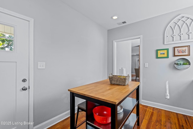 dining room featuring baseboards, wood finished floors, and recessed lighting