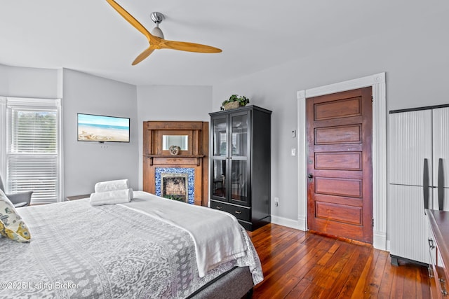 bedroom featuring dark wood-type flooring, baseboards, and ceiling fan