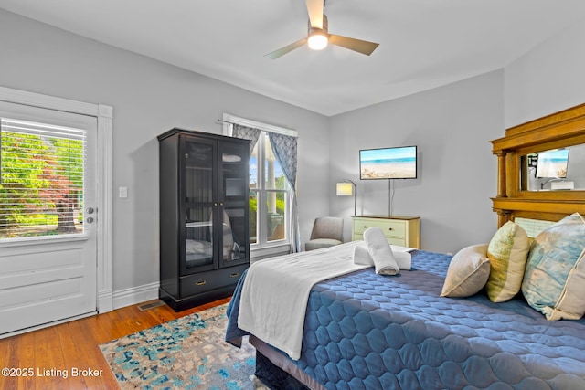 bedroom with wood finished floors, baseboards, and ceiling fan