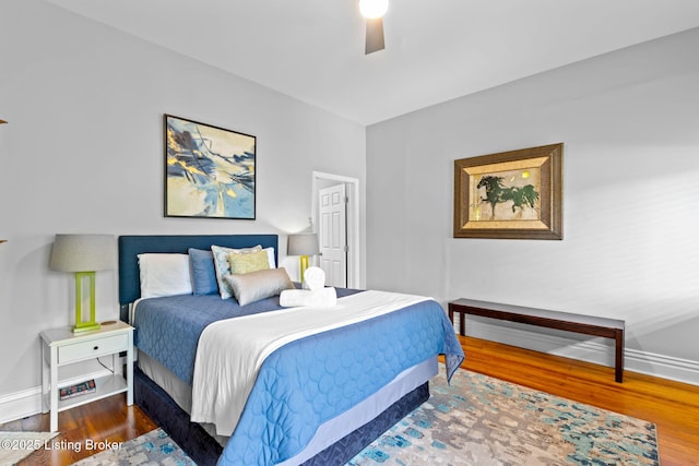 bedroom featuring baseboards, wood finished floors, and a ceiling fan